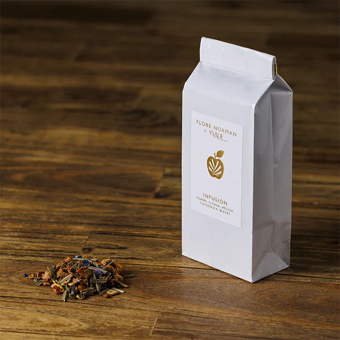 Recharge de l'infusion beauté et tas d'infusion à côté, présentés sur une table en bois